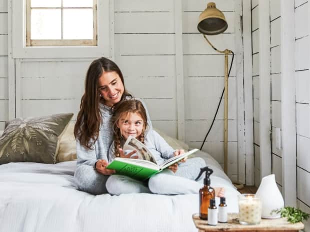 Adult and a young child reading together on a clean down comforter