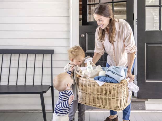 mom doing laundry with 2 children